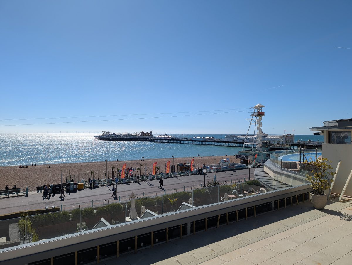 Brighton Palace Pier stretching out to sea beyond the pebble beach and seafront promenade