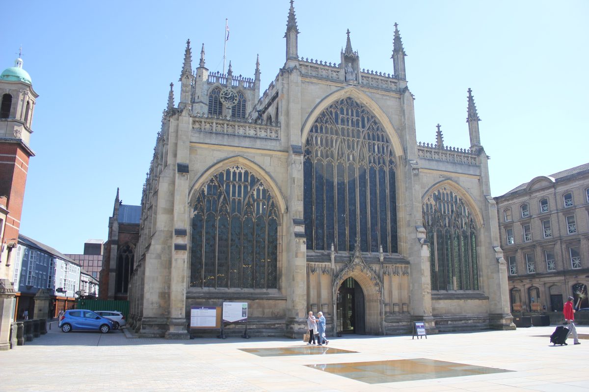 The west front of Hull Minster with its large Gothic window, facing a paved square