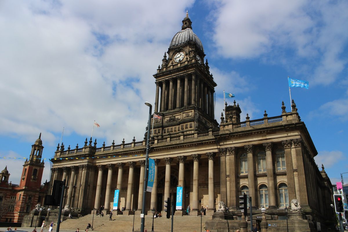 Leeds Town Hall with its columned front and domed clock tower against a partly cloudy sky