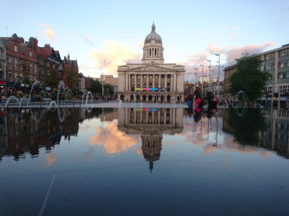 Nottingham Council House and its dome reflected in the water feature on Old Market Square at dusk